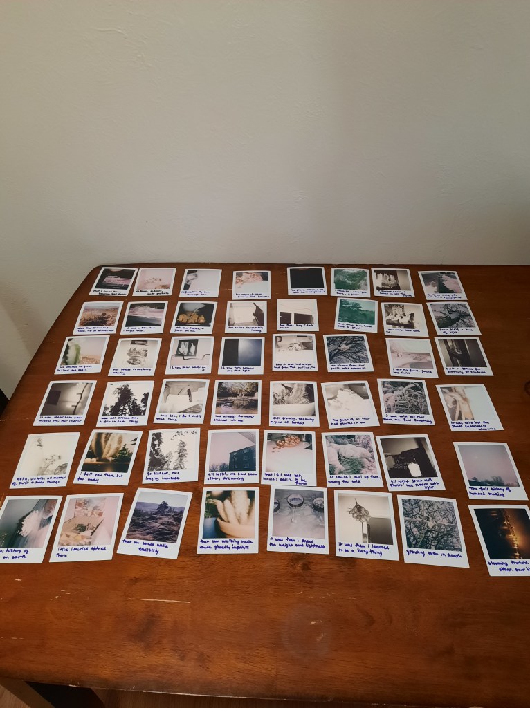 many polaroid photos fill a tabletop.
